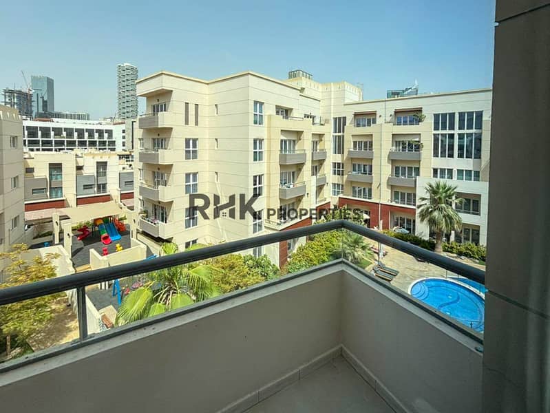 11 Apartment balcony with views of residential buildings, landscaped courtyard and swimming pool