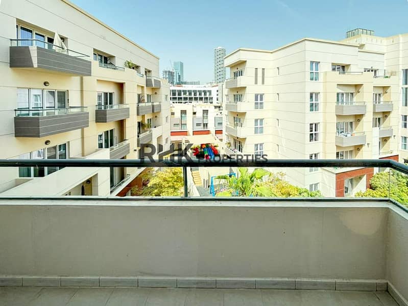 12 Apartment balcony overlooking residential buildings, landscaped courtyard and Dubai skyline