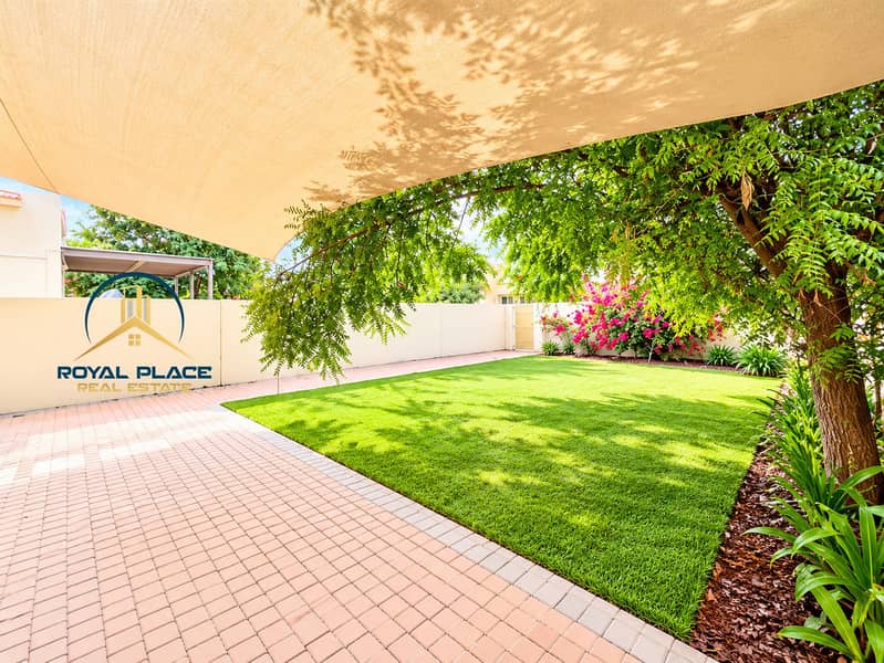 2 Sunlit Backyard Patio Under Shade Sail. png