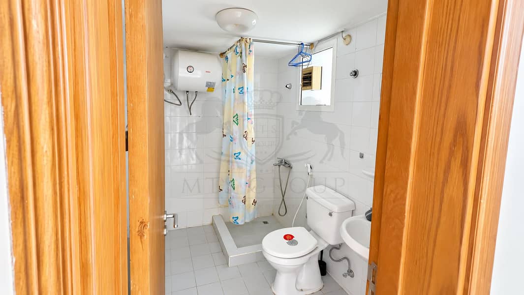 27 Bright Compact Bathroom Through Wooden Door. png
