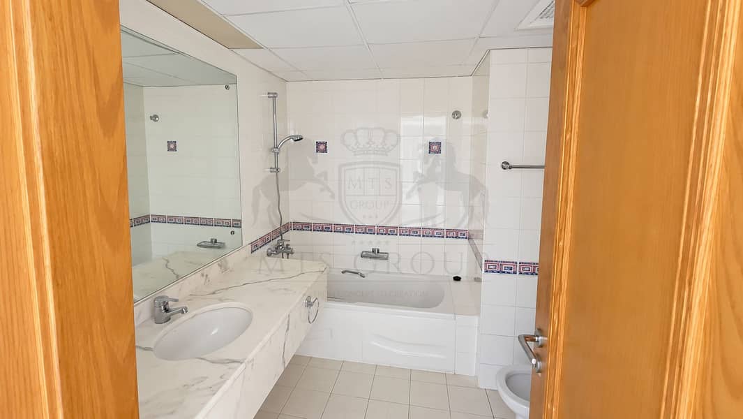 31 Bright White-Tiled Bathroom with Bathtub. png