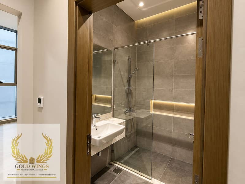 15 Modern Gray-Tiled Bathroom with Warm Lighting. png