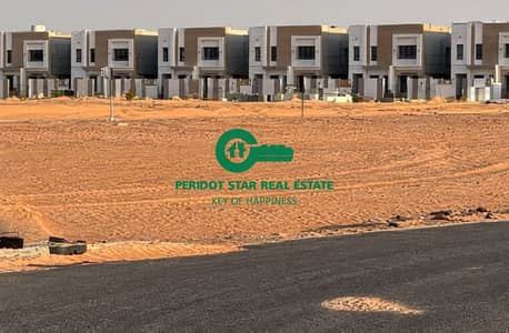 Plot for Sale in Al Salam City, Umm Al Quwain - Modern Townhomes Across a Sandy Lot. png