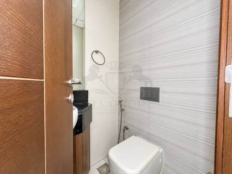 19 Modern Bathroom with Wood Door and Bidet Sprayer. png