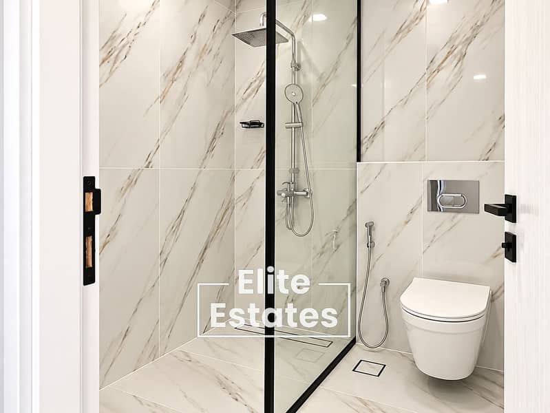 11 Modern Marble-Tiled Bathroom with Walk-In Shower. png