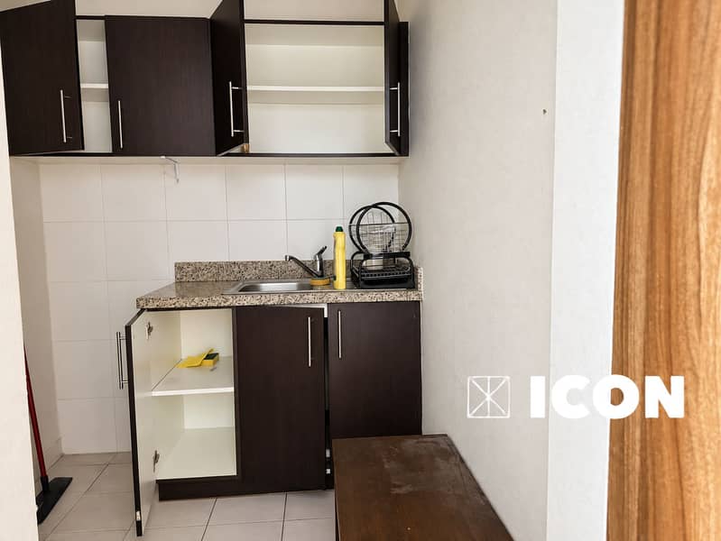 15 Polished modest kitchenette with dark cabinetry. png