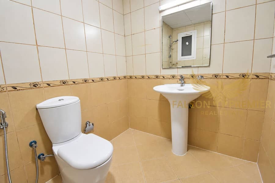 14 Bright tiled bathroom with wood cabinetry-1. png