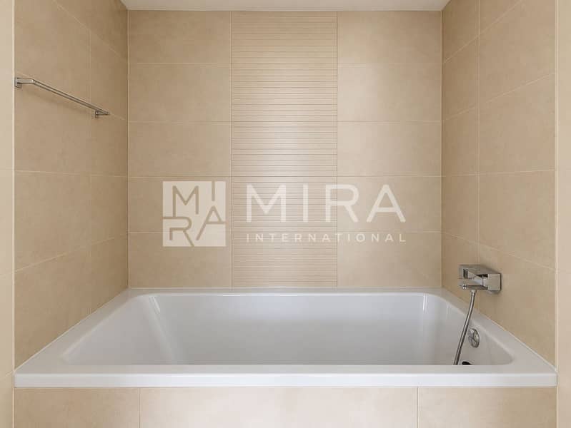 9 Clean bathroom with beige tiled bathtub-9