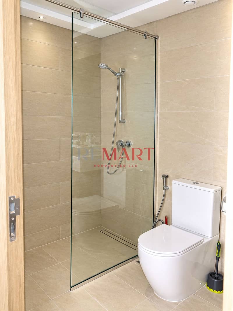 7 Modern Beige-Tiled Bathroom with Glass Shower. png