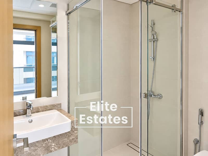 13 Modern Beige Bathroom with Glass Shower. png
