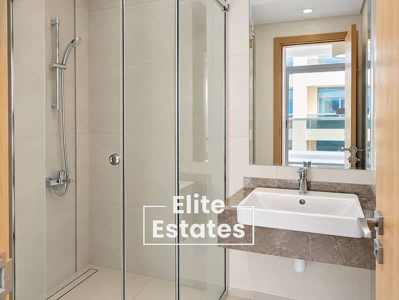 16 Modern Beige-Tiled Bathroom with Glass Shower. png