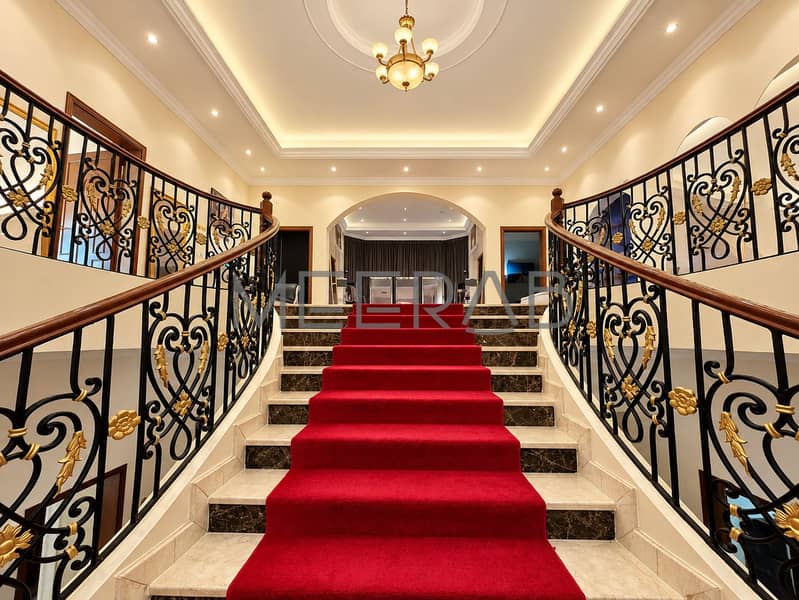 9 Grand Red-Carpeted Staircase Foyer. png
