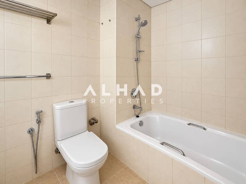 7 Minimal Beige Tile Bathroom with Tub and Toilet. png