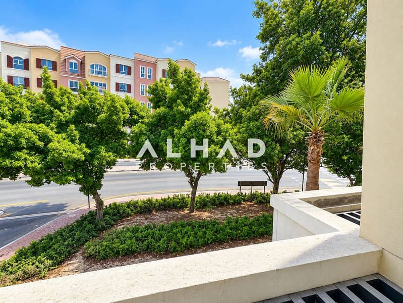 11 Sunlit Balcony Overlook of Tree-Lined Residences. png