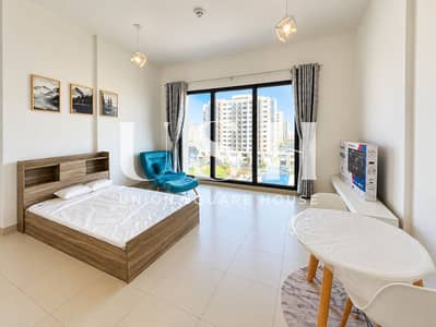 Studio zum Miete in Town Square, Dubai - Bright Modern Studio Apartment with Teal Lounge Chair. png