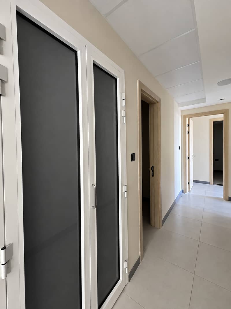 15 Couloir moderne aux portes vitrées sombres. png