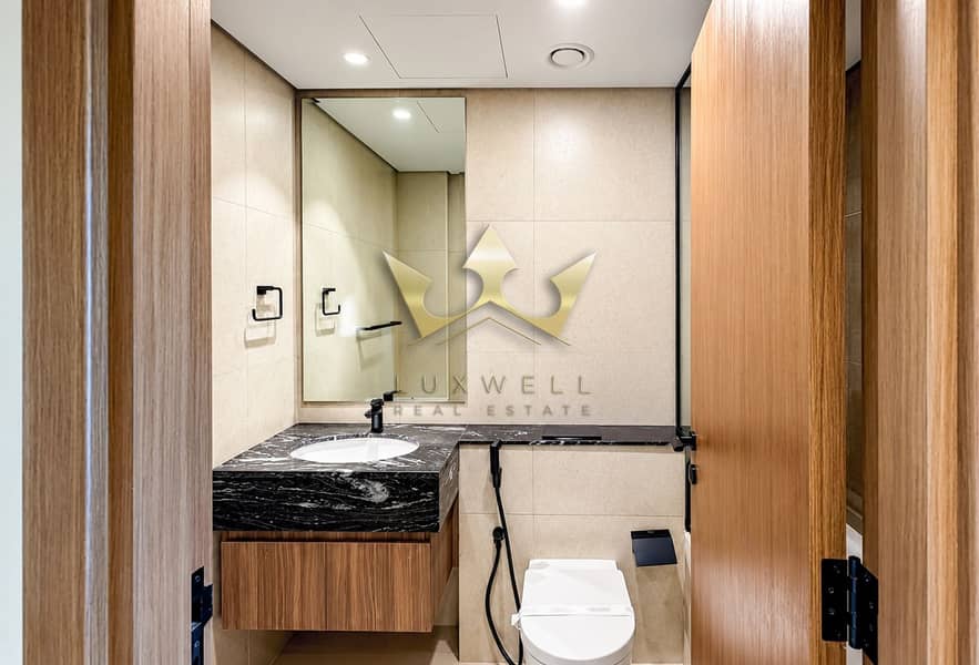 7 Modern Beige Marble Bathroom with Wood Door Framing. png