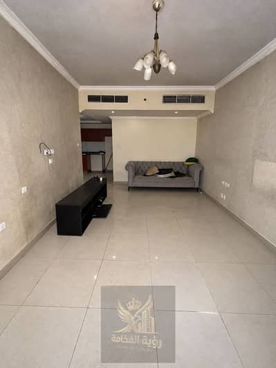 استوديو  للايجار في التعاون، الشارقة - Empty Beige Living Room with Chandelier and Sofa. png