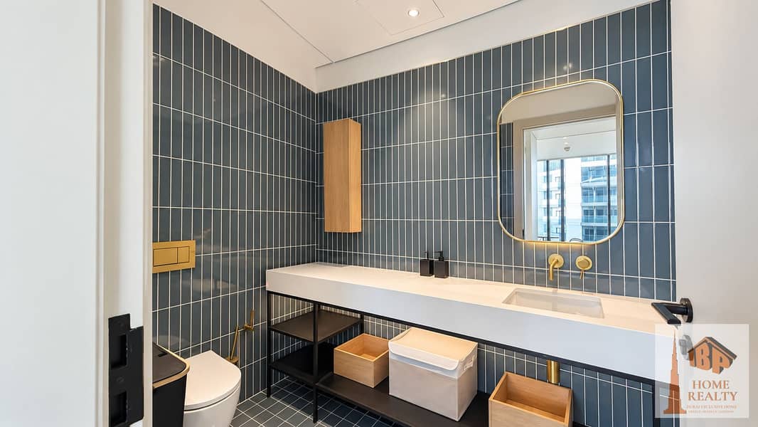 8 Bright blue-tile bathroom with brass fixtures. png