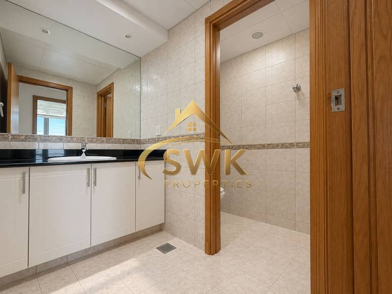 10 Elegant Beige-Tiled Bathroom with Vanity and Stall. png