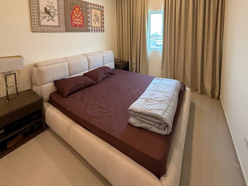 6 Bedroom with brown bedding, tufted headboard and decorative wall panels above the bed.