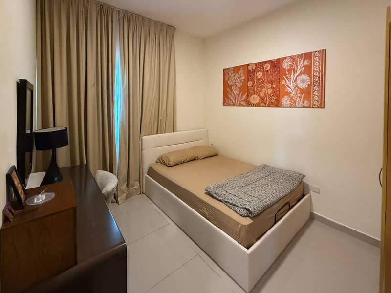 8 Bedroom with single bed, brown dresser, mirror and full-length curtains.