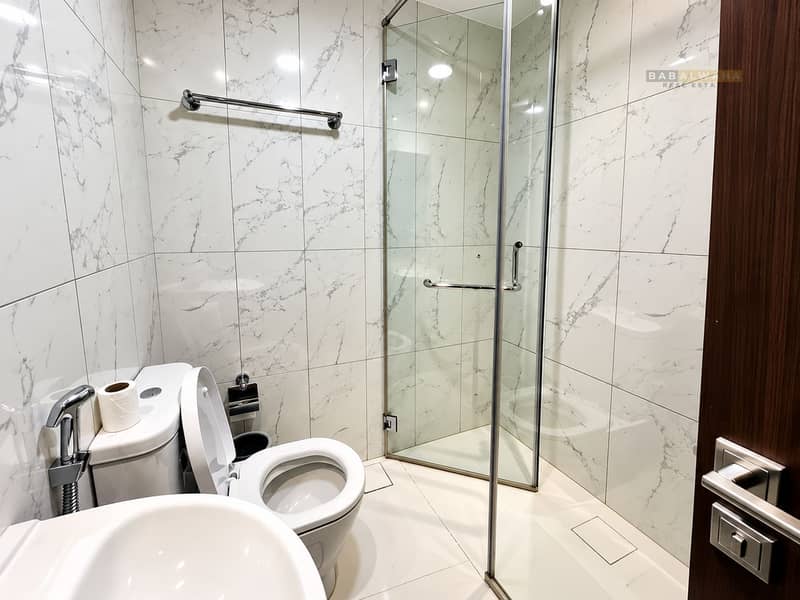 19 Modern Marble-Tile Bathroom with Glass Shower. png