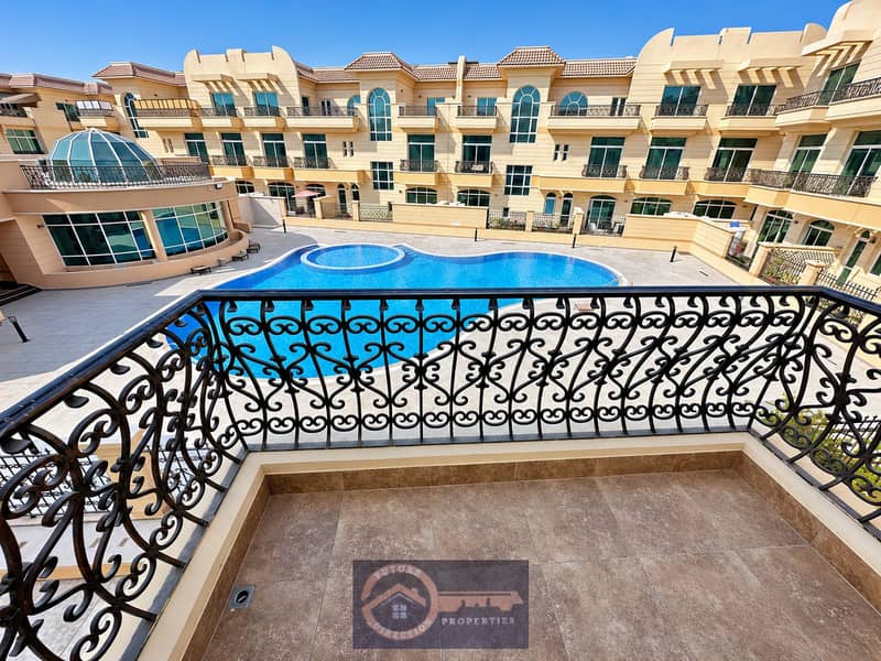 2 Sunlit balcony overlooking blue pool. png
