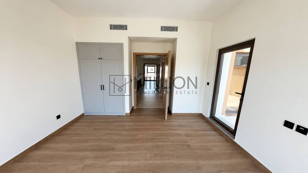 6 Empty wood-floored bedroom with balcony doors-2. png