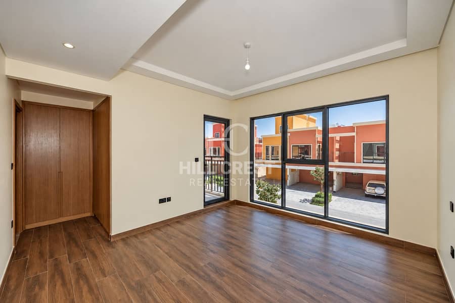 17 Sunlit Empty Bedroom with Townhouse Views. png