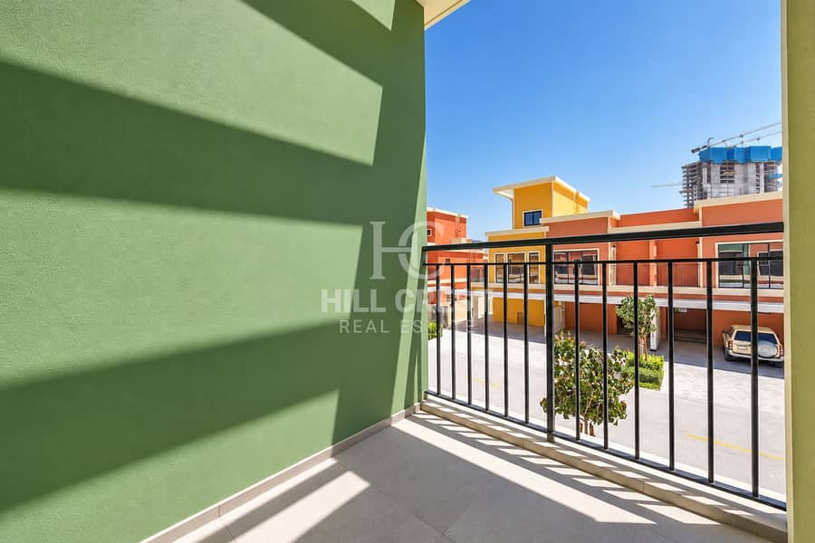 18 Sunlit Green Balcony Overlooking Modern Townhomes. png