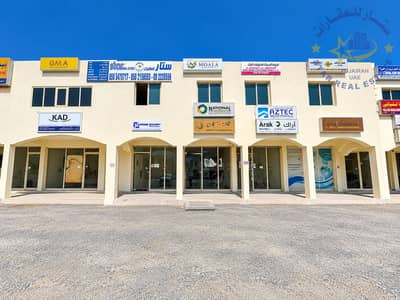 Building te Koop in Al Hayl, Fujairah - Modern Commercial Shopfronts Under Blue Skies. png