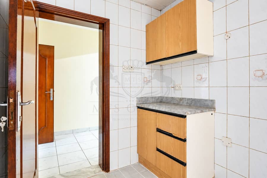 5 Bright Tiled Kitchenette with Wooden Cabinets. png