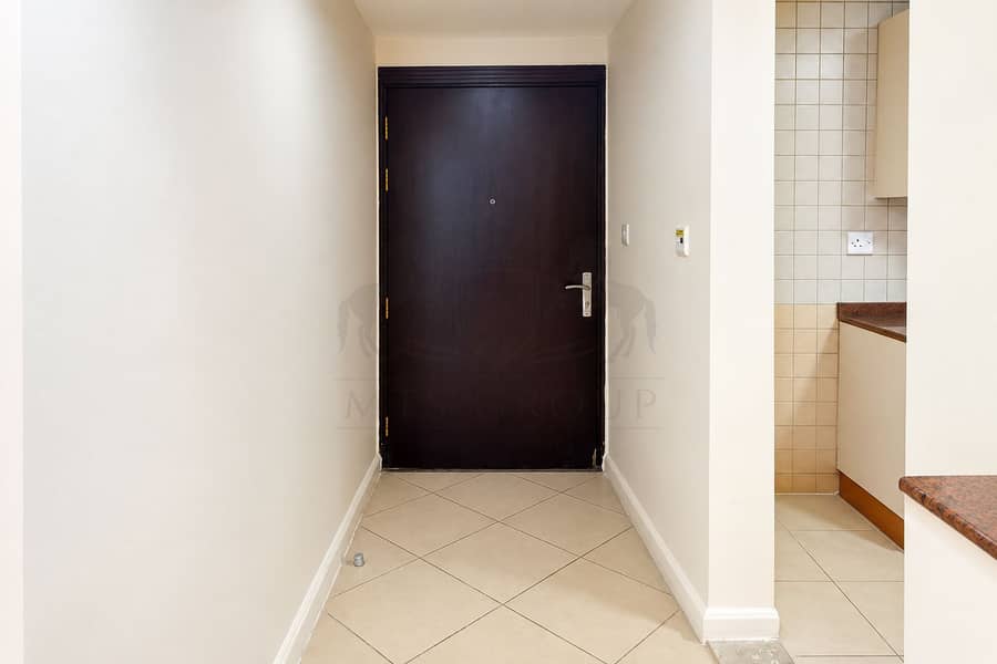 13 Wide Cream Hallway and Dark Wood Door. png