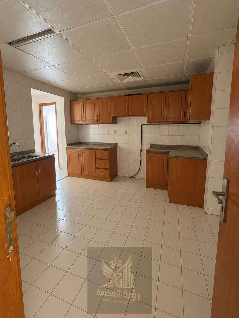 13 Empty Warm-Toned Tiled Kitchen. png