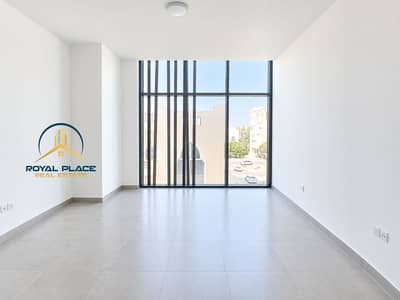Studio for Rent in Dubai Investments Park (DIP), Dubai - Bright Minimalist Room with Panoramic Windows. png