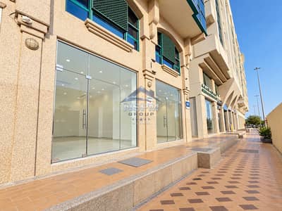 Shop de  à à louer à Al Nahyan, Abu Dhabi - Modern Stone-Clad Storefronts on a Bright Day. png