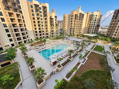 2 Bedroom Apartment for Rent in Madinat Jumeirah Living, Dubai - Sunlit poolside residence with modern balconies. png
