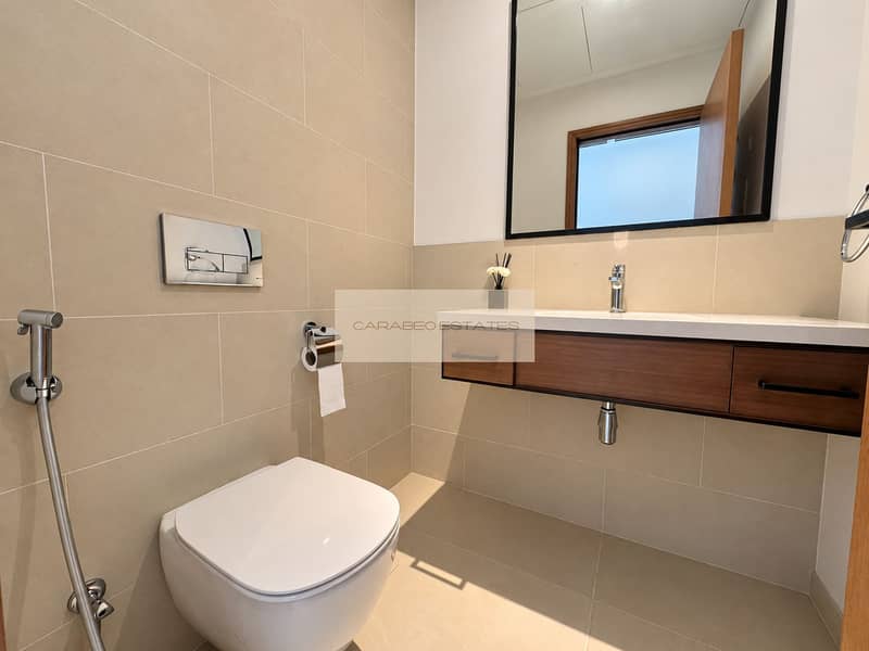 12 Bright guest bathroom with wood vanity. png